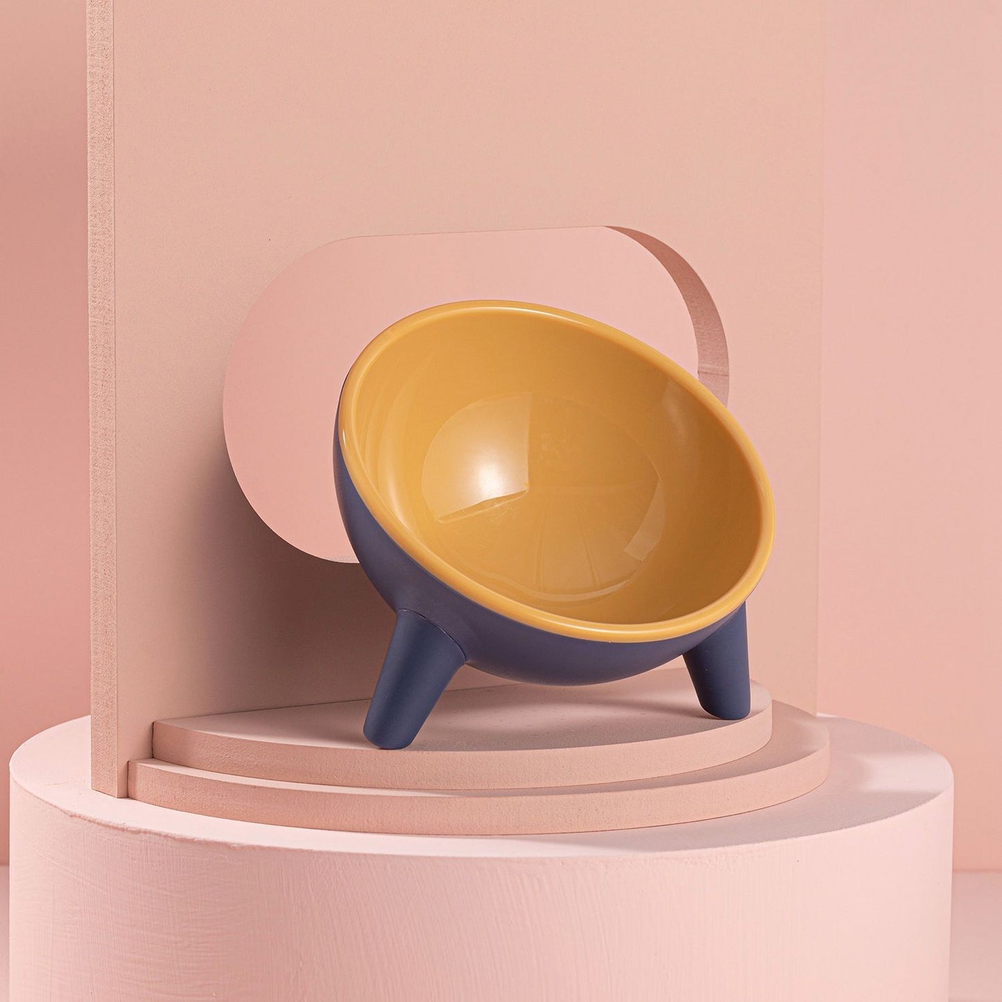 Blue exterior bowl with glossy yellow interior filled with dry kibble close-up