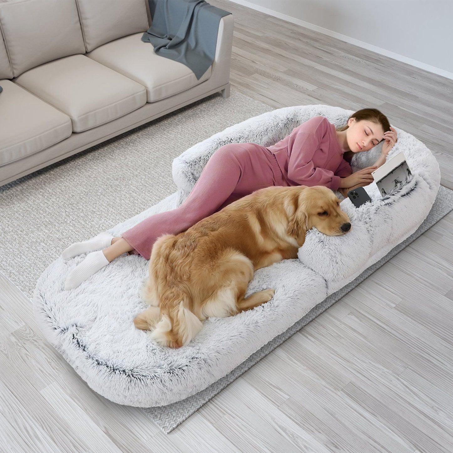 Top-down view of unfolded human-sized bed with reclining person and large dog sharing the surface