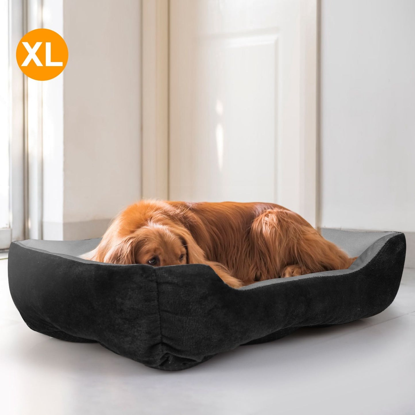 Black and grey plush dog bed in use with curled golden-brown dog, showing bolstered sides and low front opening