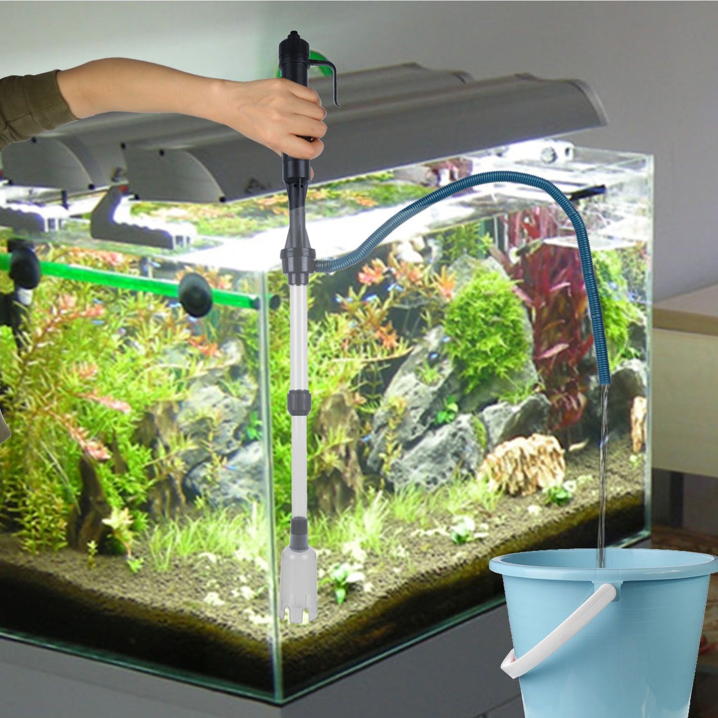 hand-held aquarium cleaner siphoning water through hose into a bucket during a water change