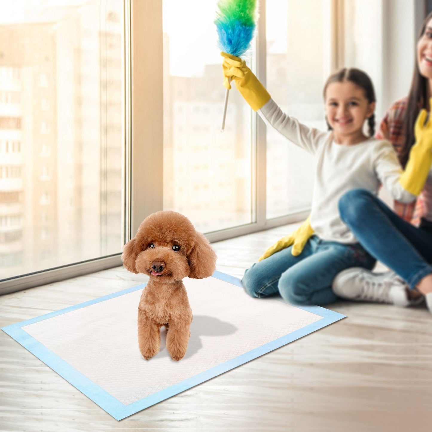 Pet training pad on floor in family room with dog and caregivers playing nearby