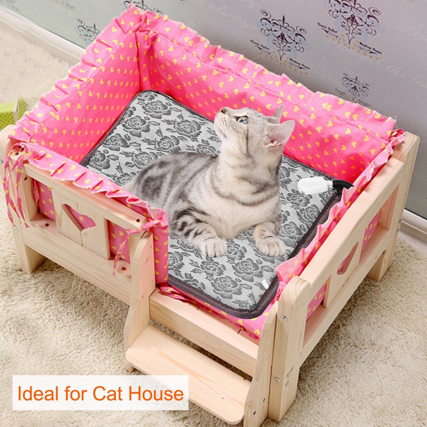 Cat resting on floral heating pad inside a wooden cat house