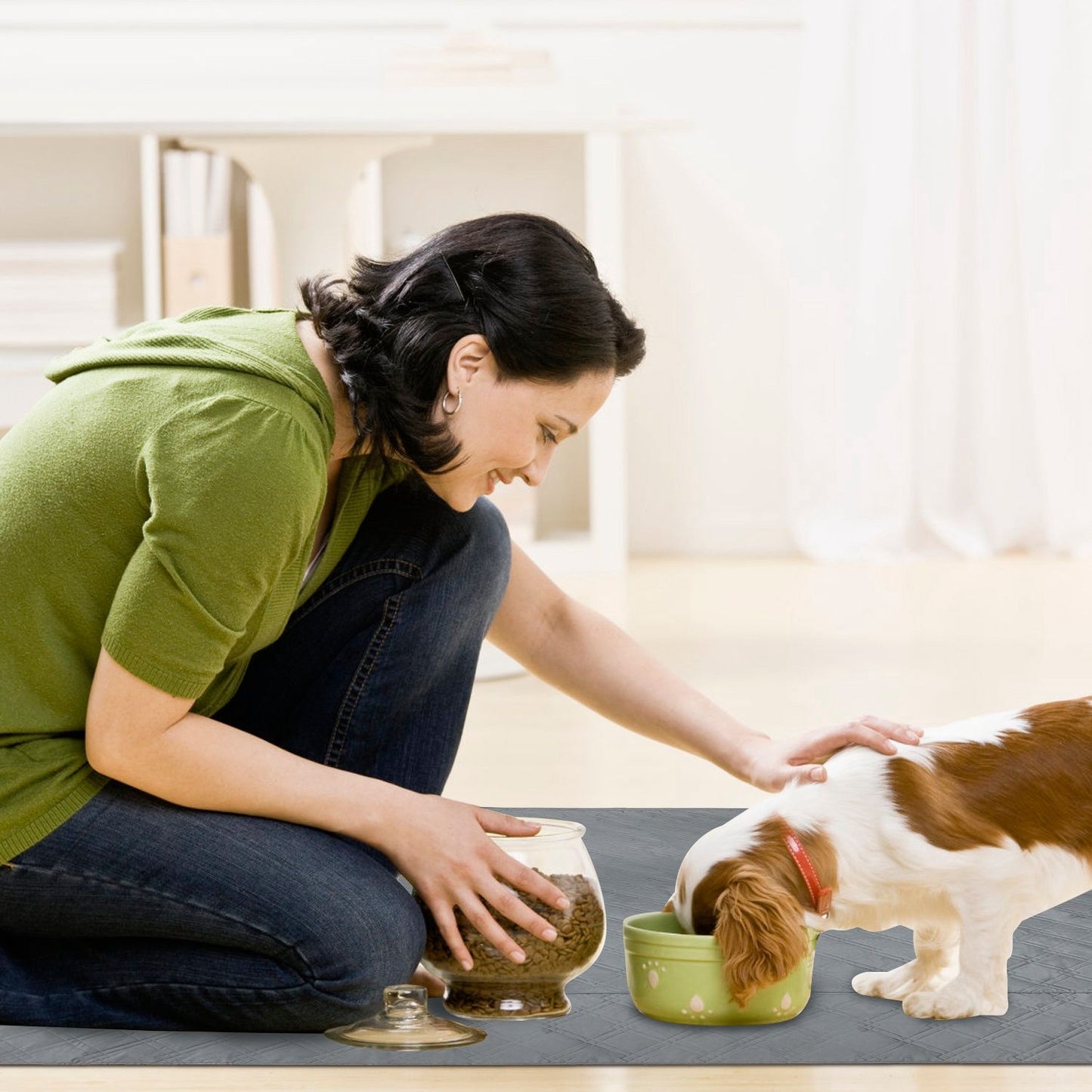 Grey pad placed under food bowls while dog eats to protect floor from spills