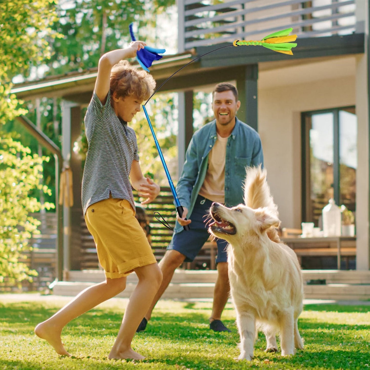 Family playing in backyard using flirt pole to exercise a golden dog near a house