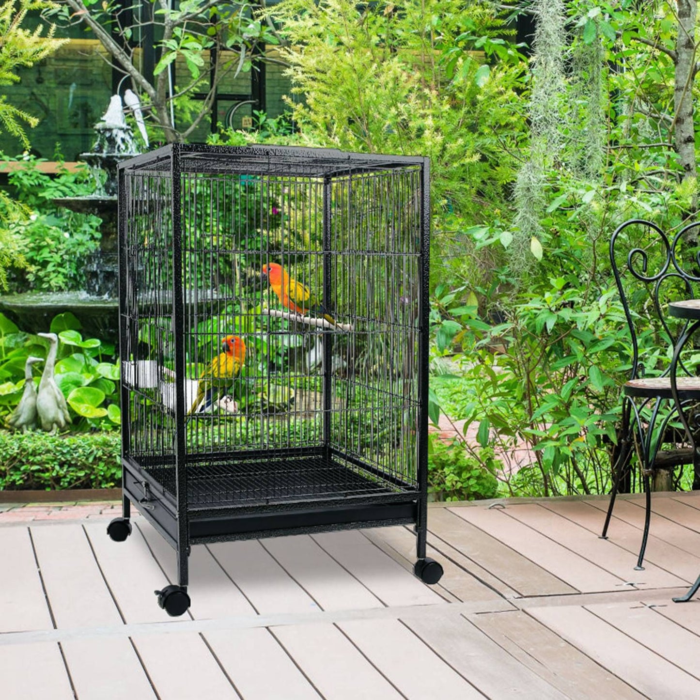 Bird cage on a patio in a garden setting with two small parrots inside