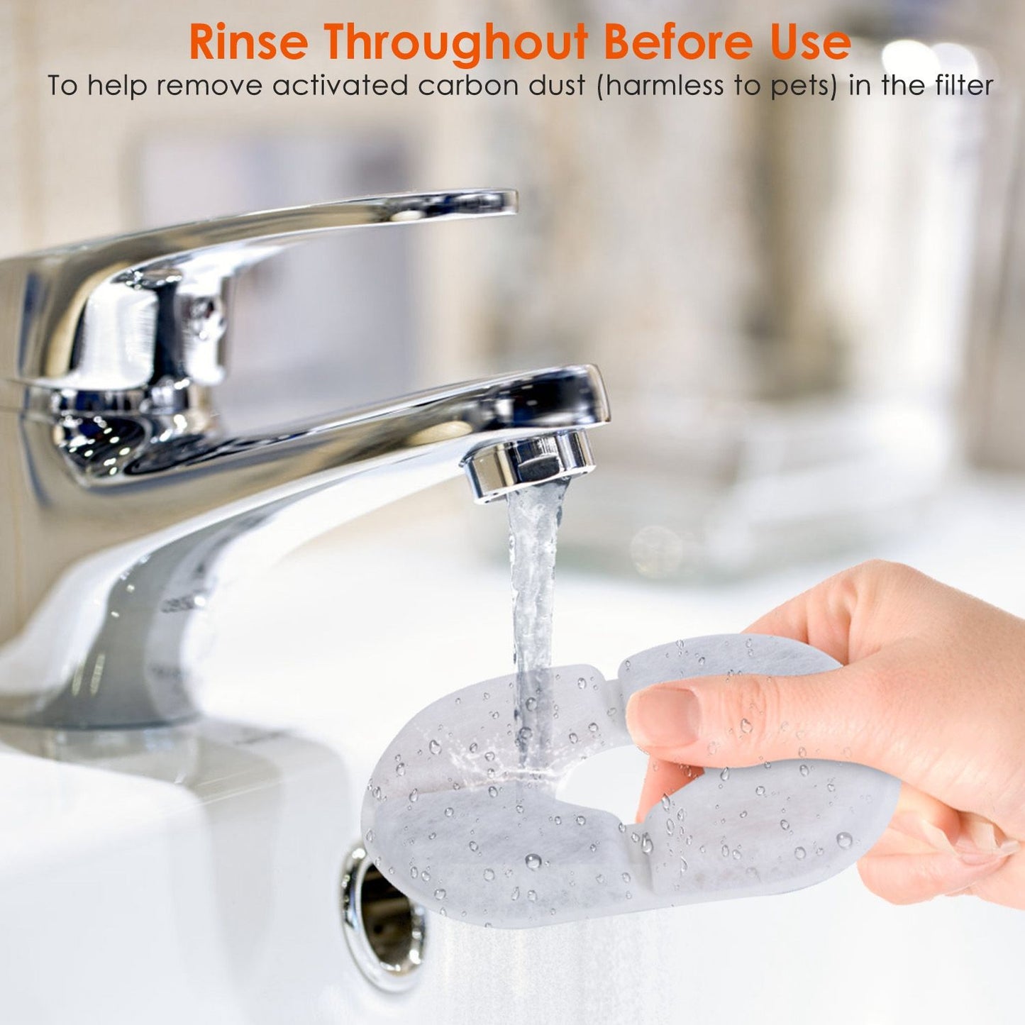 Hand rinsing a circular fountain filter under a kitchen faucet before installation