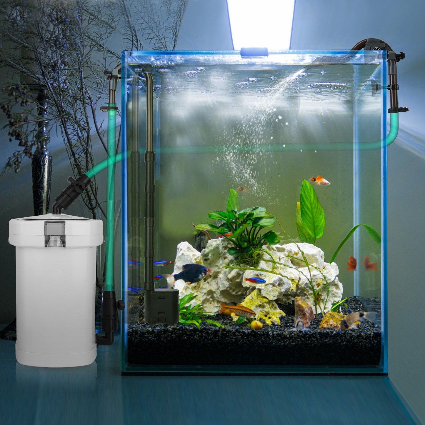 Canister filter installed beside a planted aquarium with hoses and water return creating surface flow