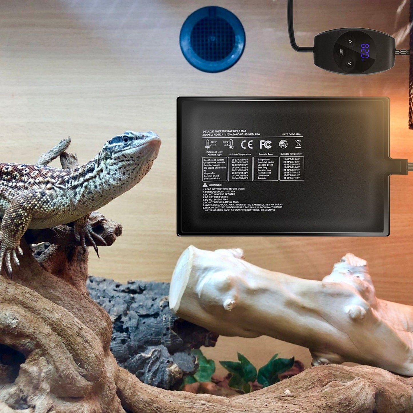Heating pad mounted inside a terrarium wall with a lizard nearby and controller outside the tank