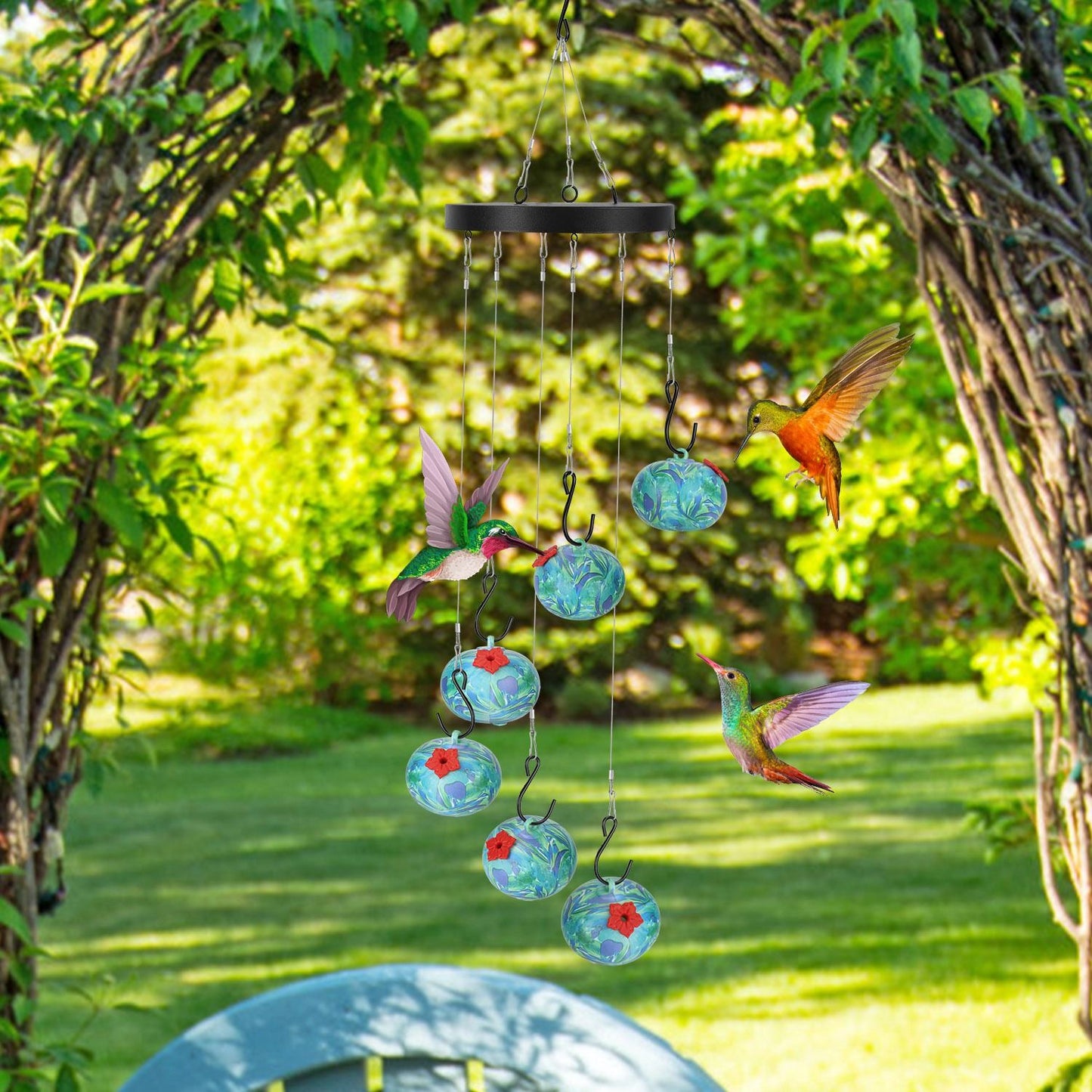 hummingbird feeder hanging under a garden arch surrounded by greenery and hummingbirds