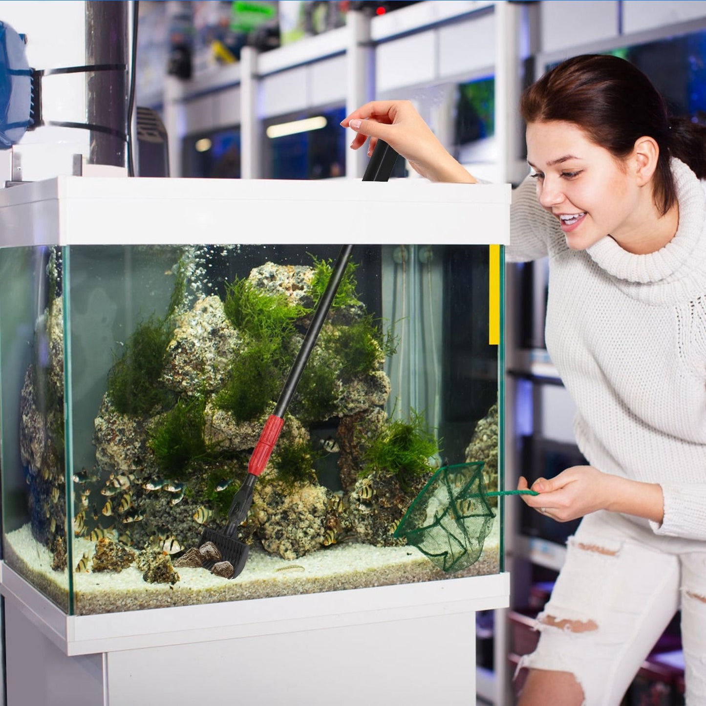 Person using gravel rake on extendable handle to comb and loosen aquarium substrate