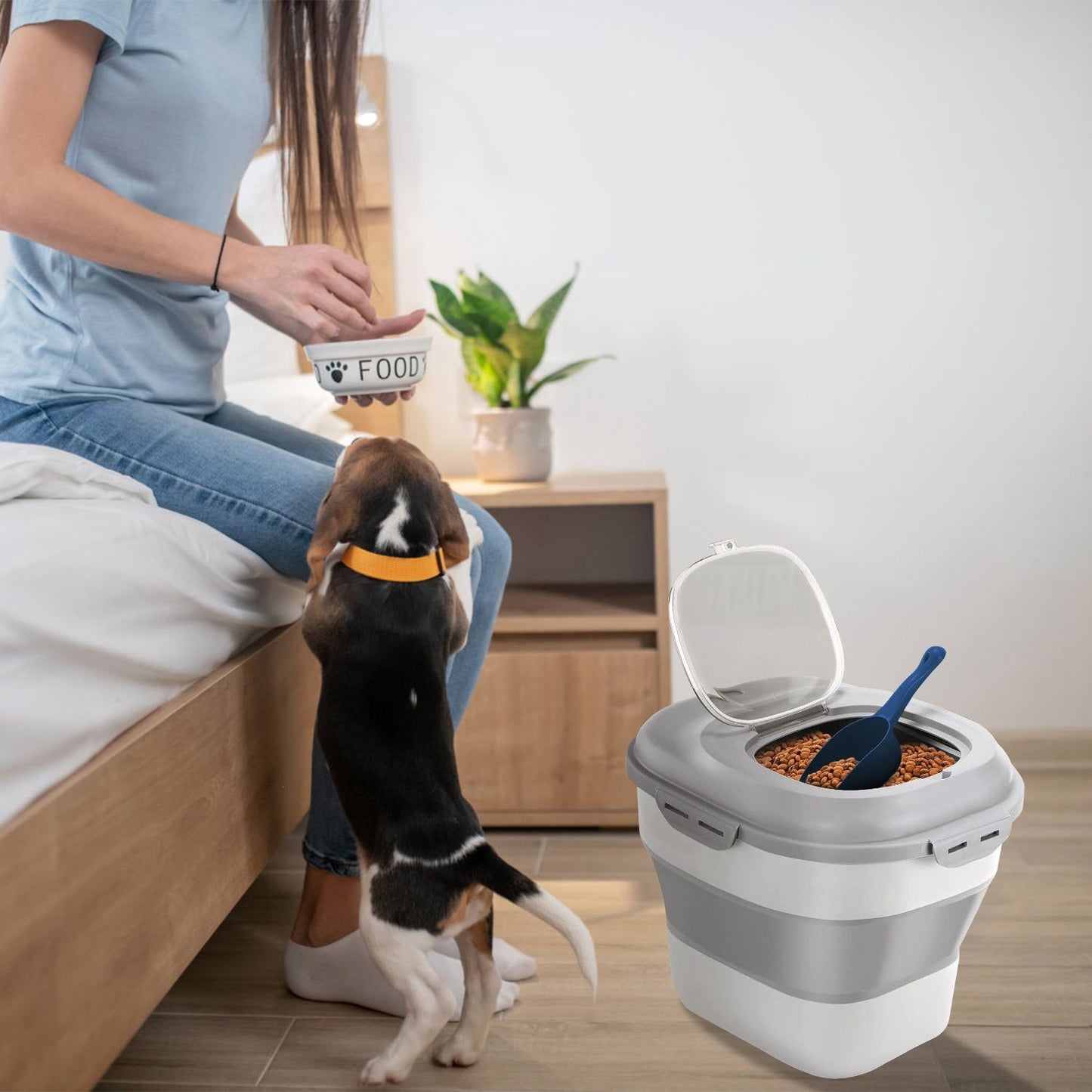Unfolded food container with open lid next to person feeding a small dog by the bed