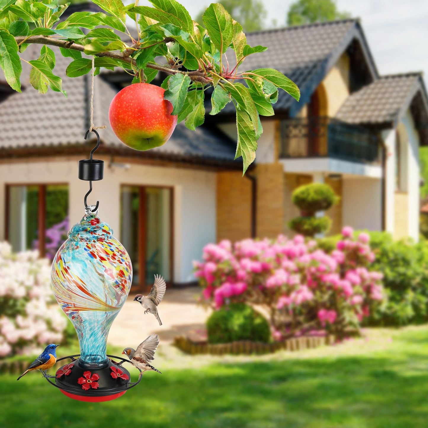 Blue feeder shown hanging beside walking couple in an outdoor park scene