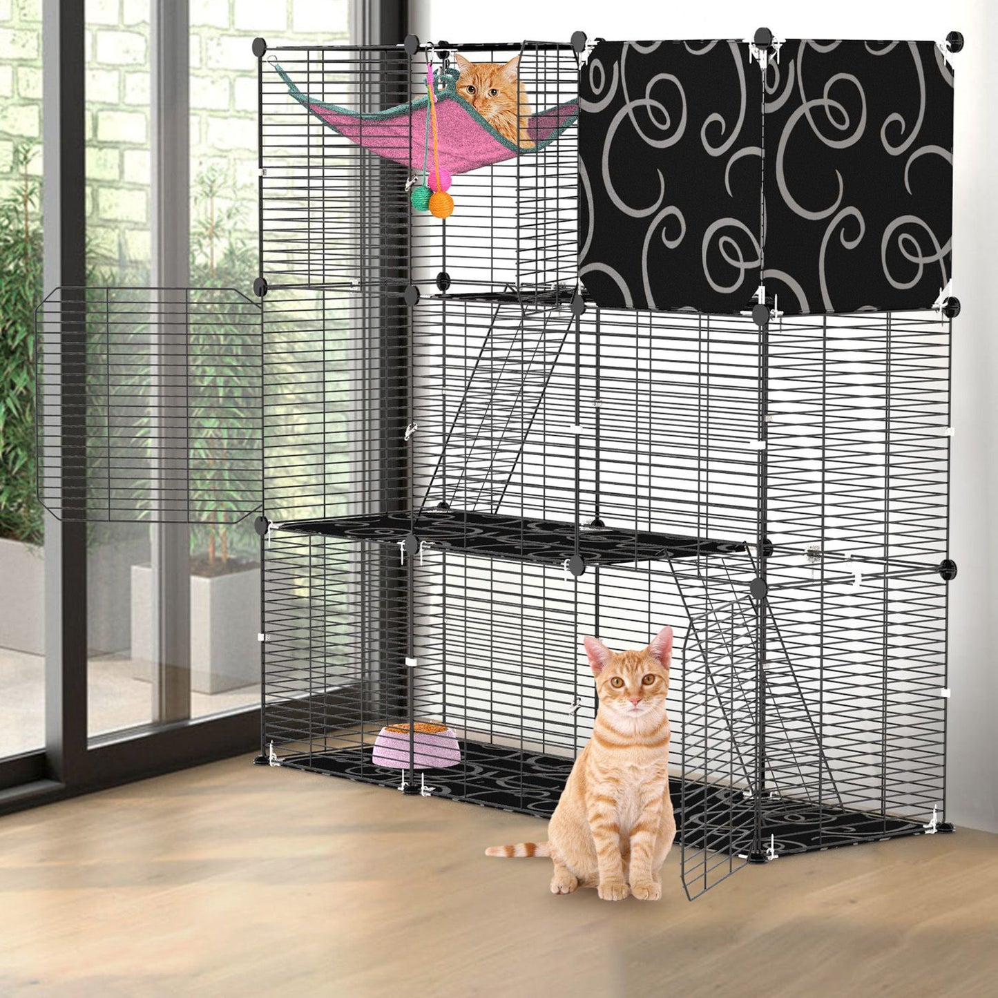 Freestanding 3-tier cat cage near glass doors with hammock and open side gate, cat for scale