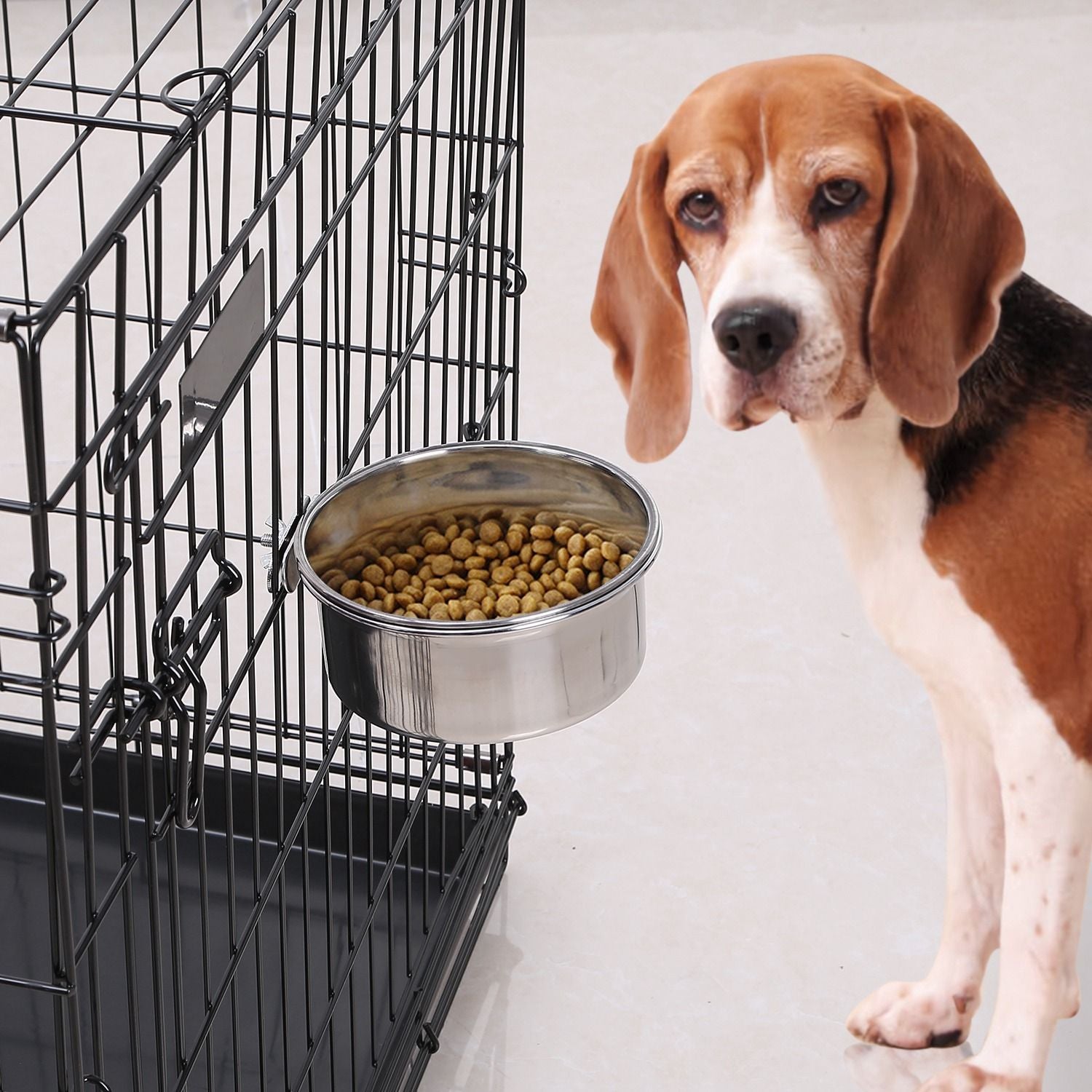 Hanging stainless steel bowl clamped to a wire pet crate filled with kibble