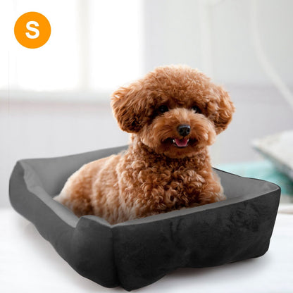 Curly-haired small dog lounging in gray plush pet bed showing bolsters and cushion