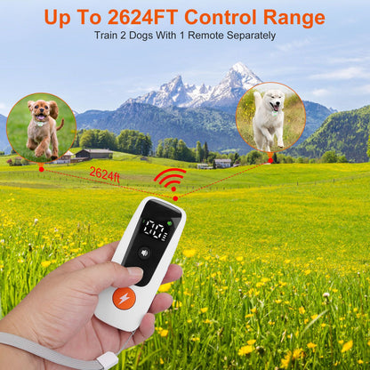 Hand-held white remote with numeric display demonstrating 2624ft control range to two dogs
