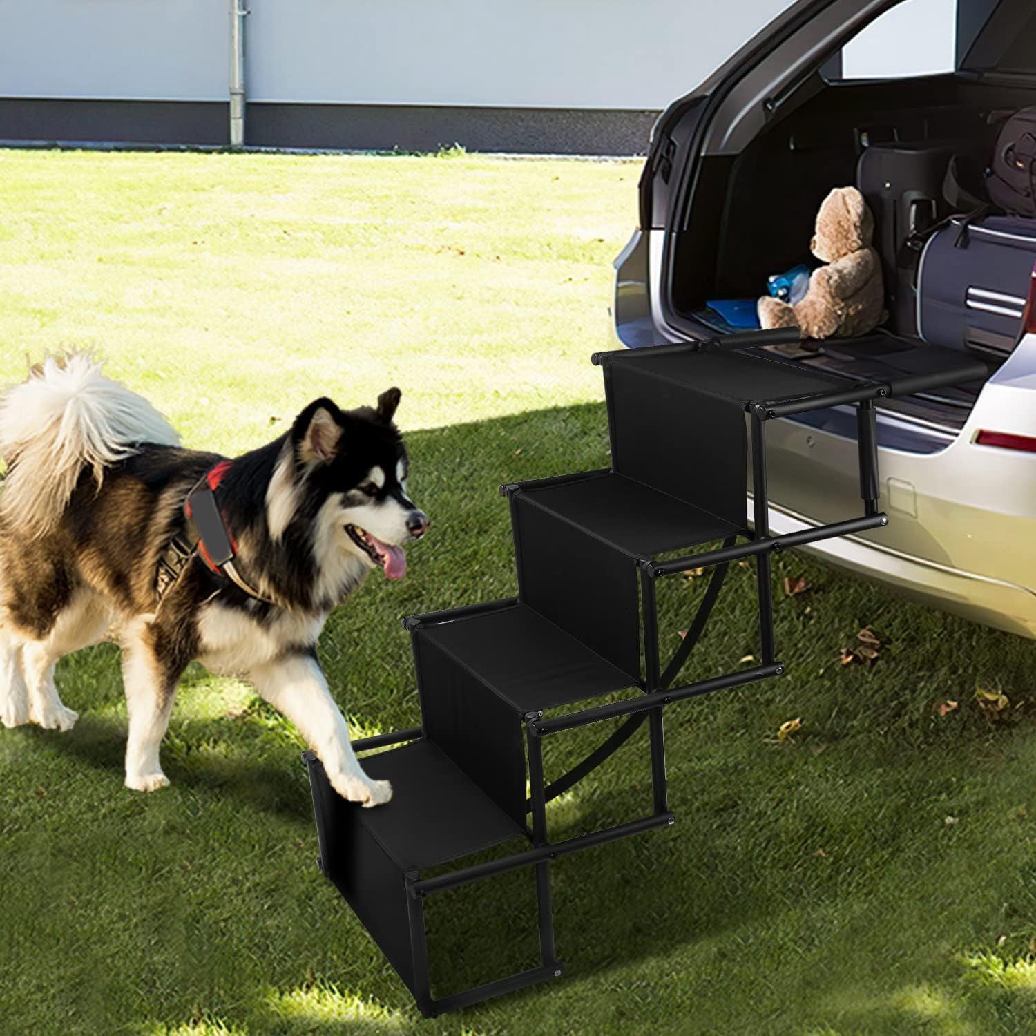 Angled view of four-step dog ramp at tailgate showing tubular frame and non-slip fabric steps