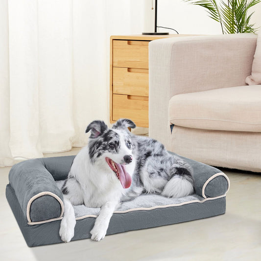 dark grey bolstered dog bed with plush surface and a white-gray dog lounging