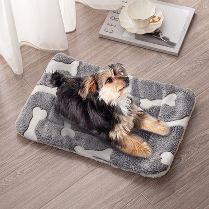 Grey bone-pattern flannel dog mat on wood floor with small dog lying on it