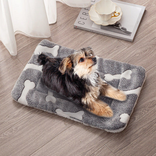 Grey bone-pattern flannel dog mat on wood floor with small dog lying on it