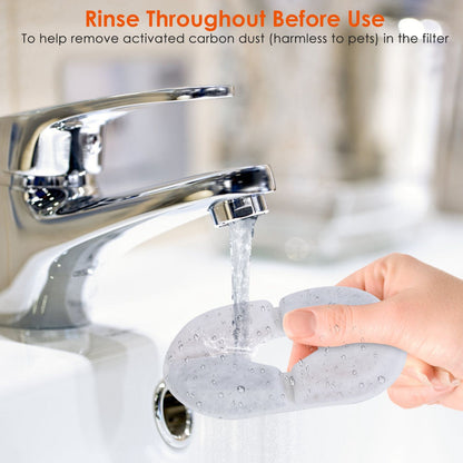 Hand rinsing a circular fountain filter under a kitchen faucet before installation