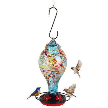 Blue feeder hanging from branch with an apple and birds in a garden setting