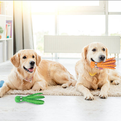 Two golden retrievers indoors with one carrying an orange octopus toy and another near a green toy on the floor