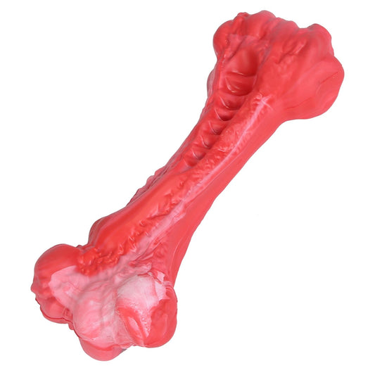 Red rubber dog chew bone with textured grooves and white marbling close-up