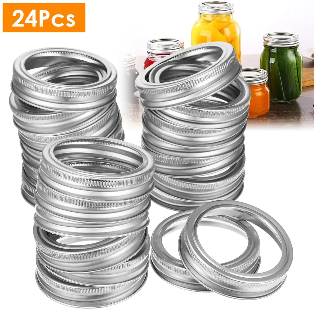 24-piece set of silver metal canning jar lids arranged on a countertop, designed for home canning and preserving food, with colorful jars in the background.