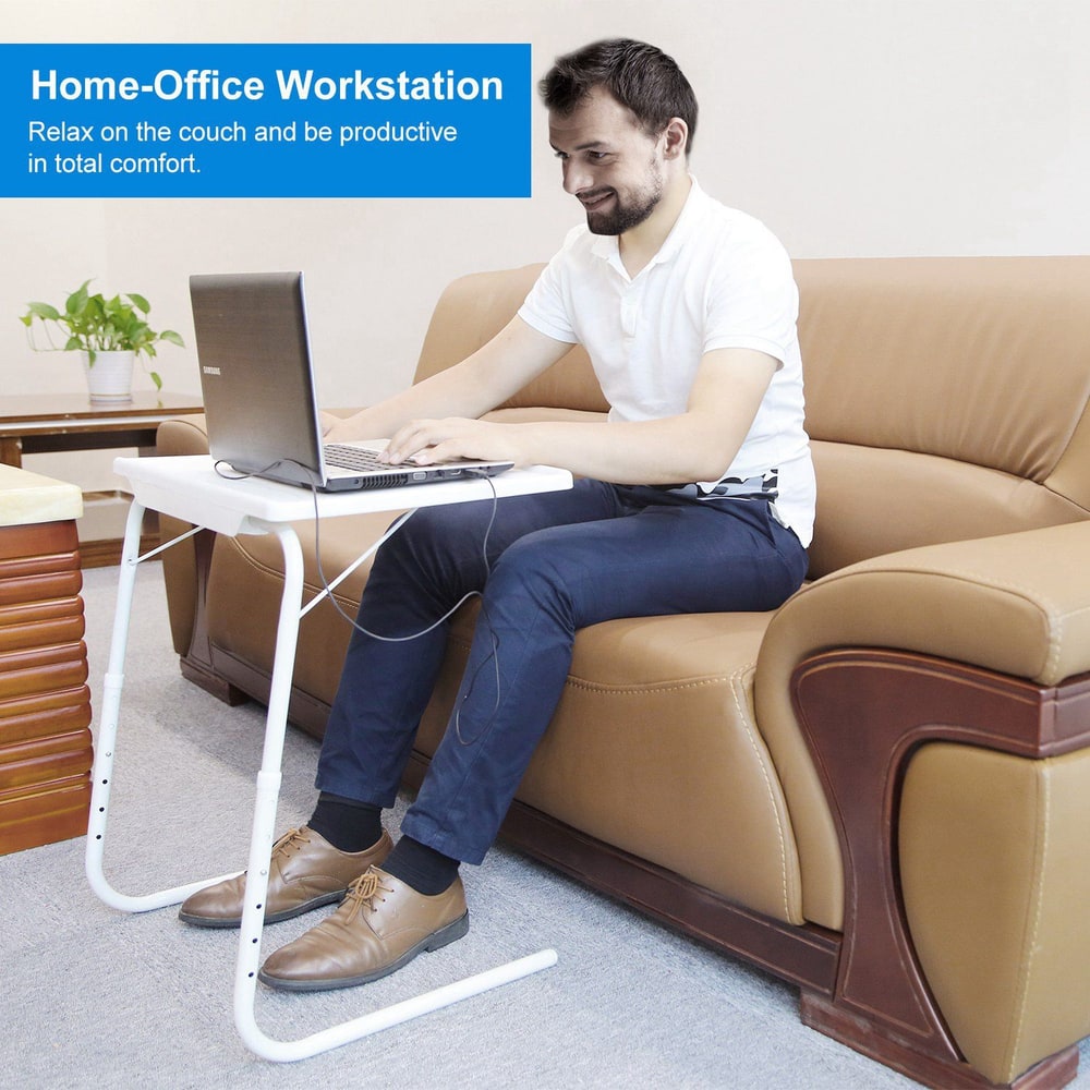 Home-office workstation setup featuring a man comfortably working on a laptop while seated on a couch, highlighting productivity in a cozy environment.