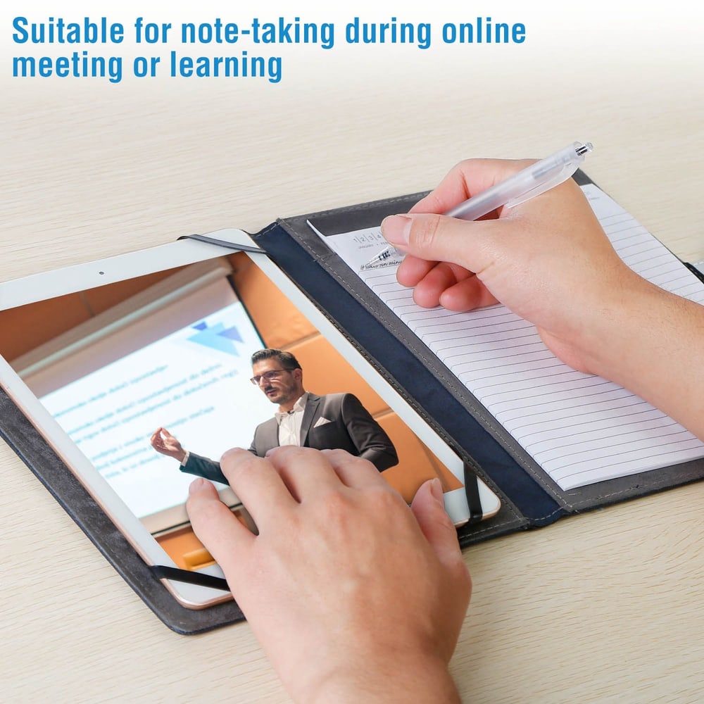 Hand holding a pen, taking notes on a notepad while viewing an online presentation on a tablet, showcasing a convenient note-taking solution for remote learning and meetings.