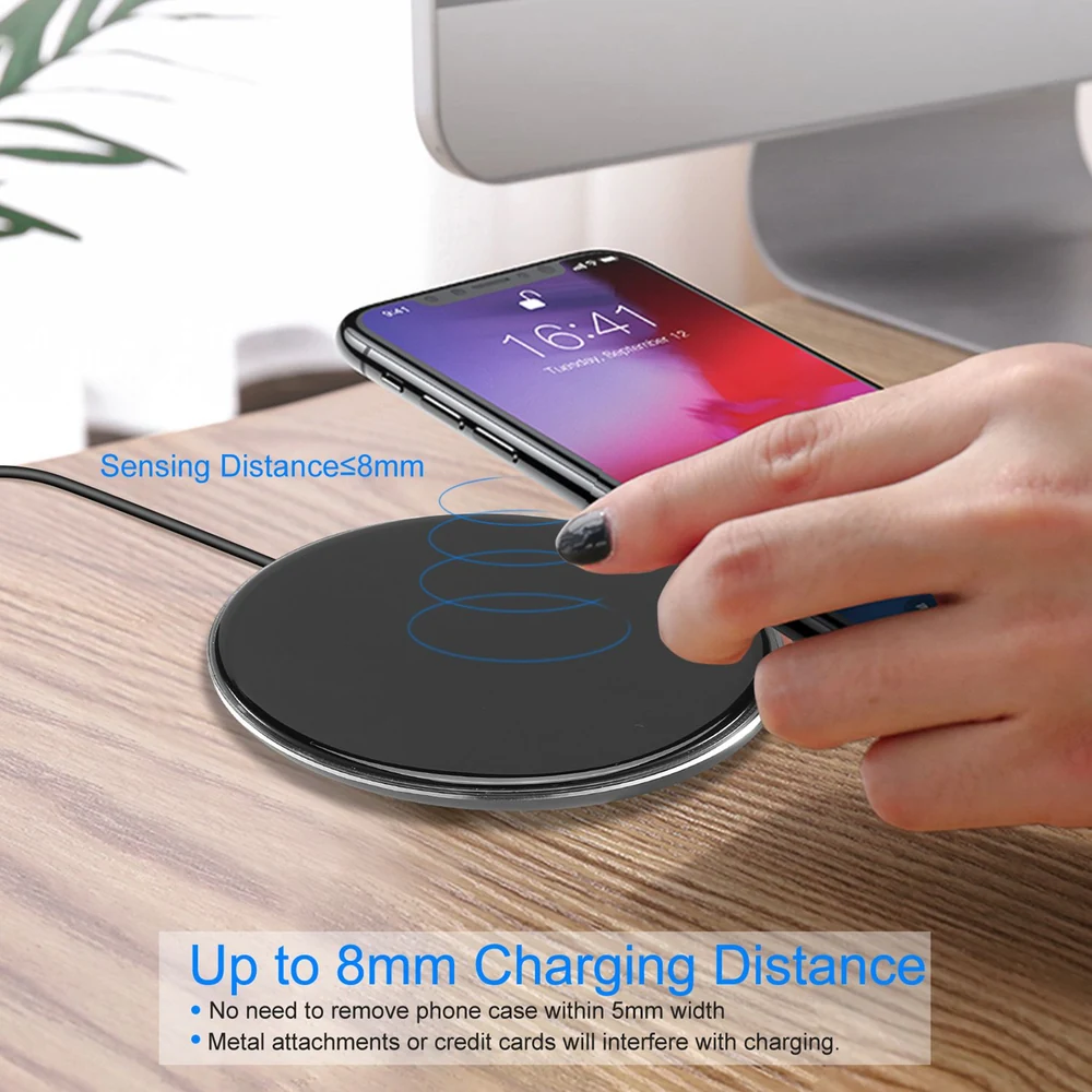 Wireless phone charger with sensing distance up to 8mm, demonstrating easy charging with a smartphone placed on a wooden table, showcasing user-friendly design and compatibility with phone cases.