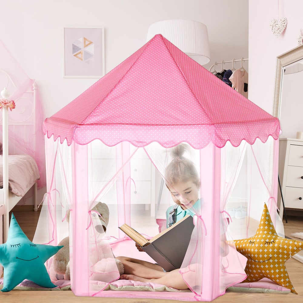 Pink play tent with polka dots, featuring a child reading inside, surrounded by colorful star-shaped cushions, set in a cozy bedroom.