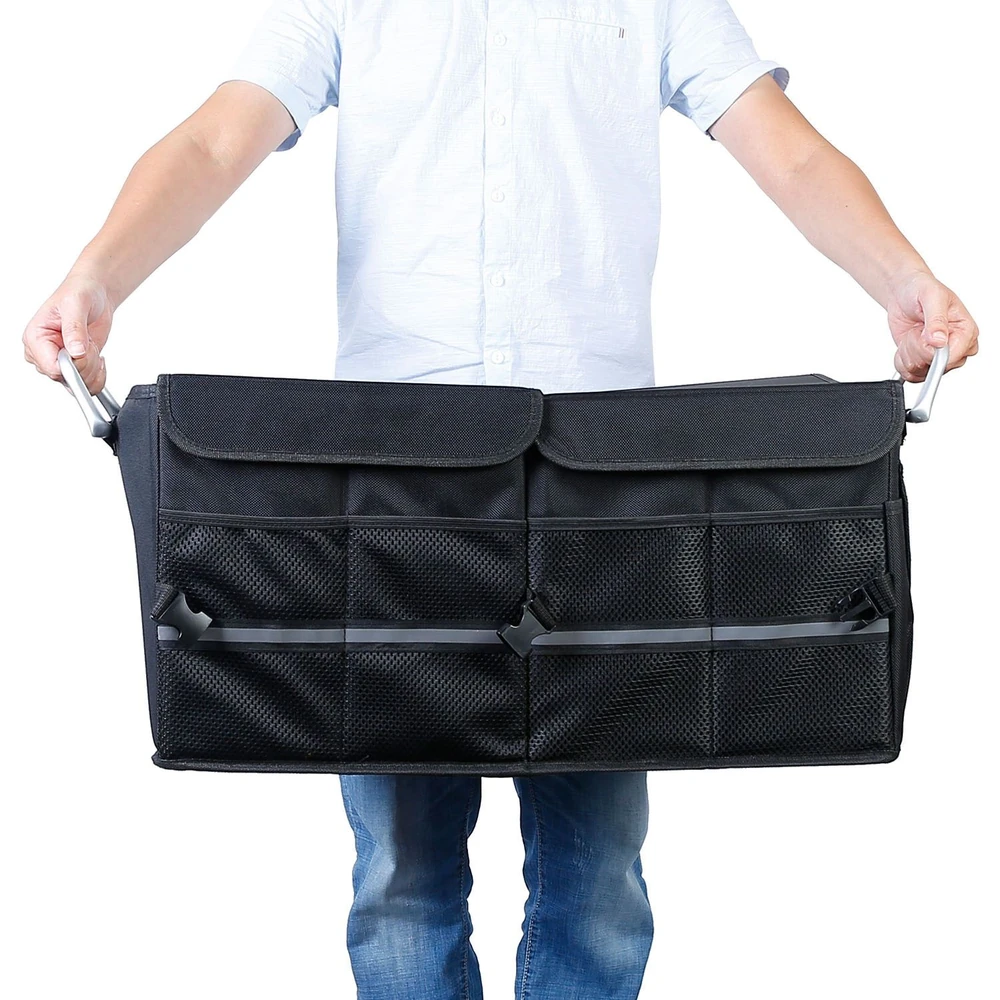 Person holding a large black storage organizer bag with mesh pockets, ideal for efficient storage and organization.