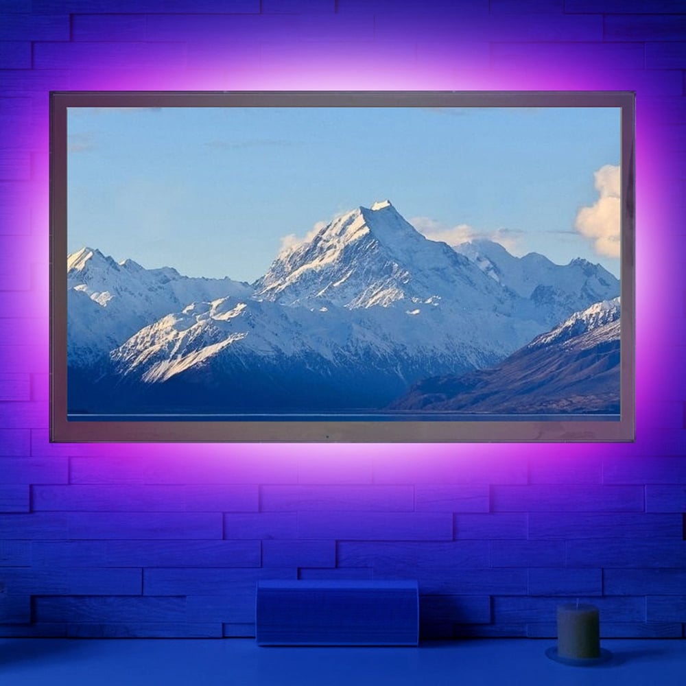 Beautiful mountain landscape displayed on a modern TV with ambient purple lighting, showcasing snow-capped peaks and serene blue sky, perfect for home décor and entertainment.