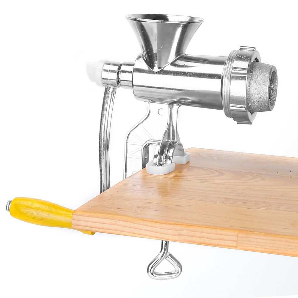 Stainless steel manual meat grinder with yellow handle mounted on a wooden cutting board.