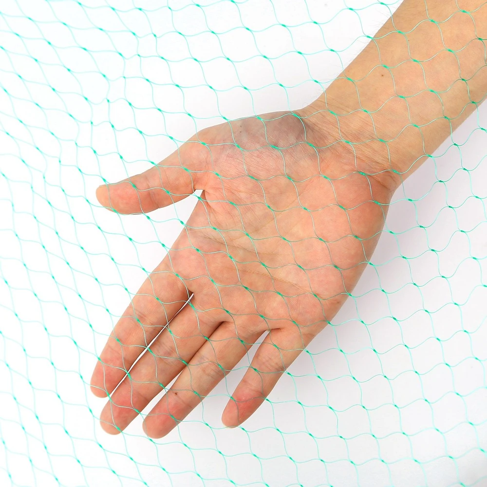 Close-up of a hand holding a fine, turquoise netting material, showcasing its texture and pattern against a white background.