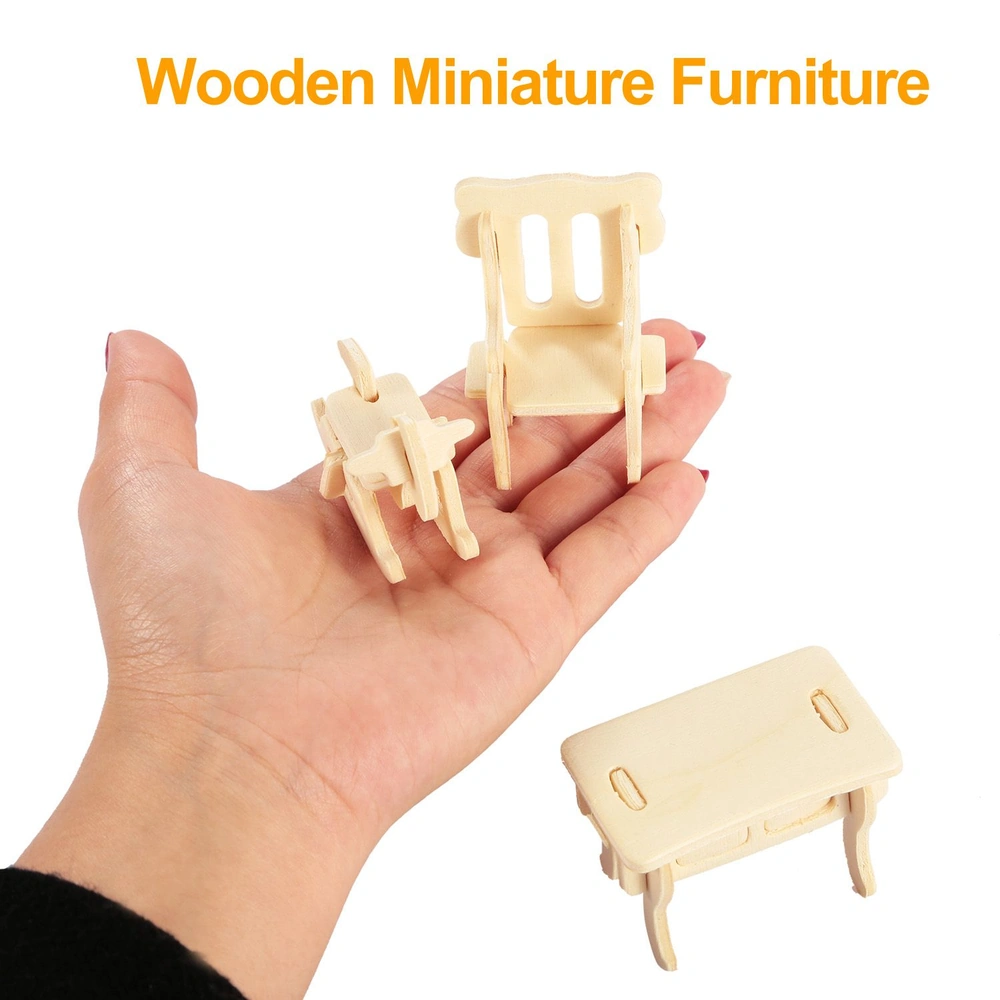 Hand holding three pieces of wooden miniature furniture including a chair, a side chair, and a small table, showcasing their intricate design and craftsmanship.