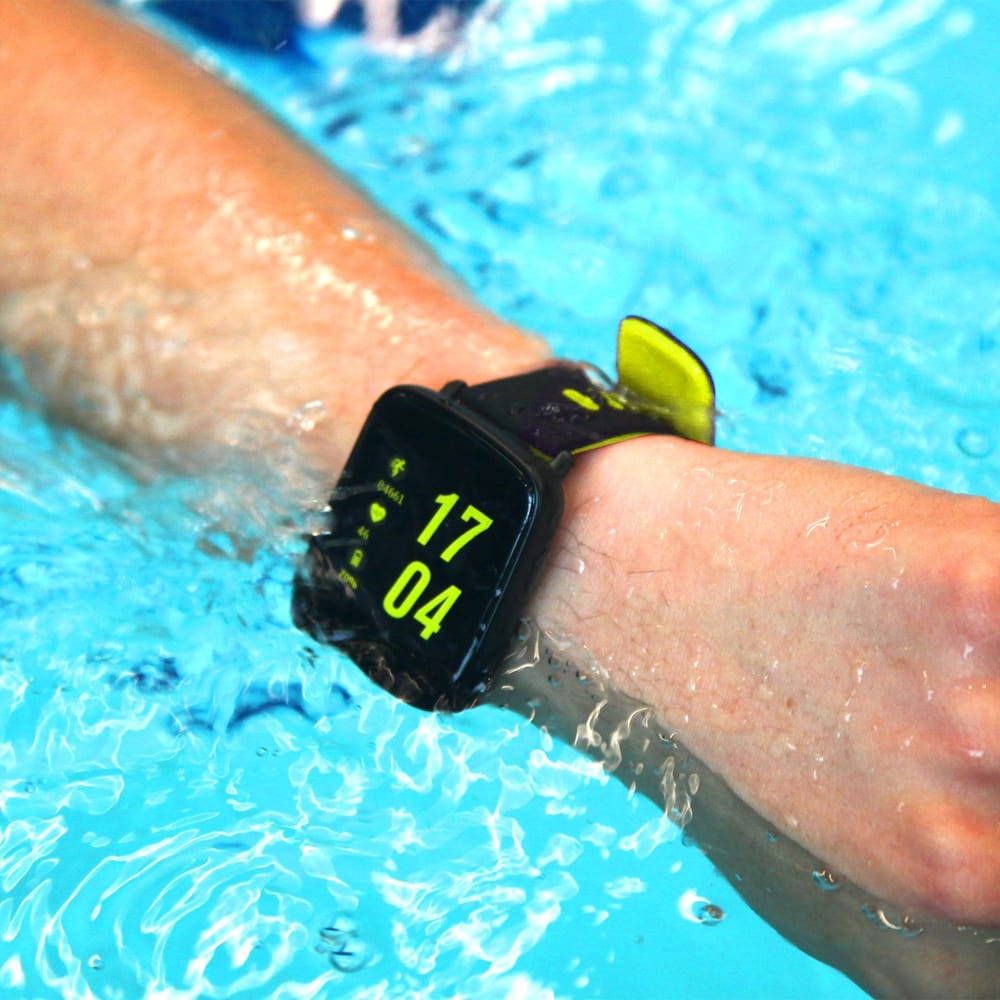 Water-resistant smartwatch displaying the time and swimming metrics on a swimmer's wrist while submerged in clear blue water.