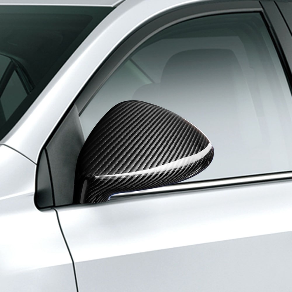 Close-up of a sleek carbon fiber side mirror on a silver car, showcasing a modern and stylish automotive accessory.