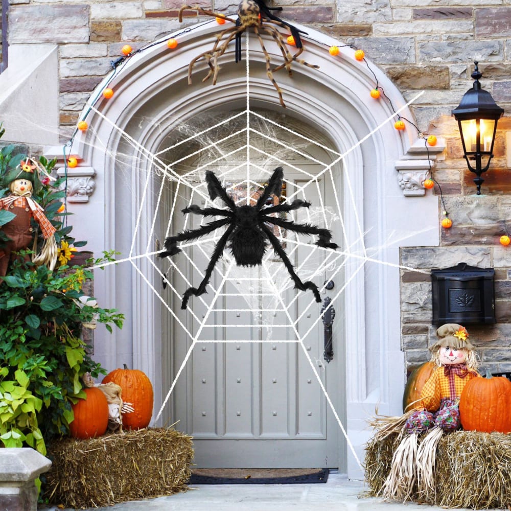 Spooky Halloween door decoration featuring a large black spider in a web, surrounded by pumpkins, hay bales, and autumn-themed decor.