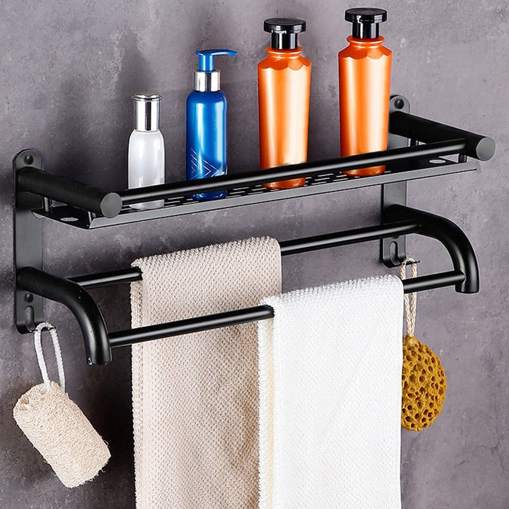 Black metal bathroom organization rack with shampoo and conditioner bottles on top and two hanging towels below, featuring a natural loofah.