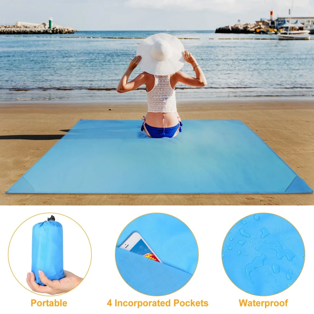 A woman relaxing on a portable waterproof blue beach mat with incorporated pockets, enjoying a sunny day by the ocean.