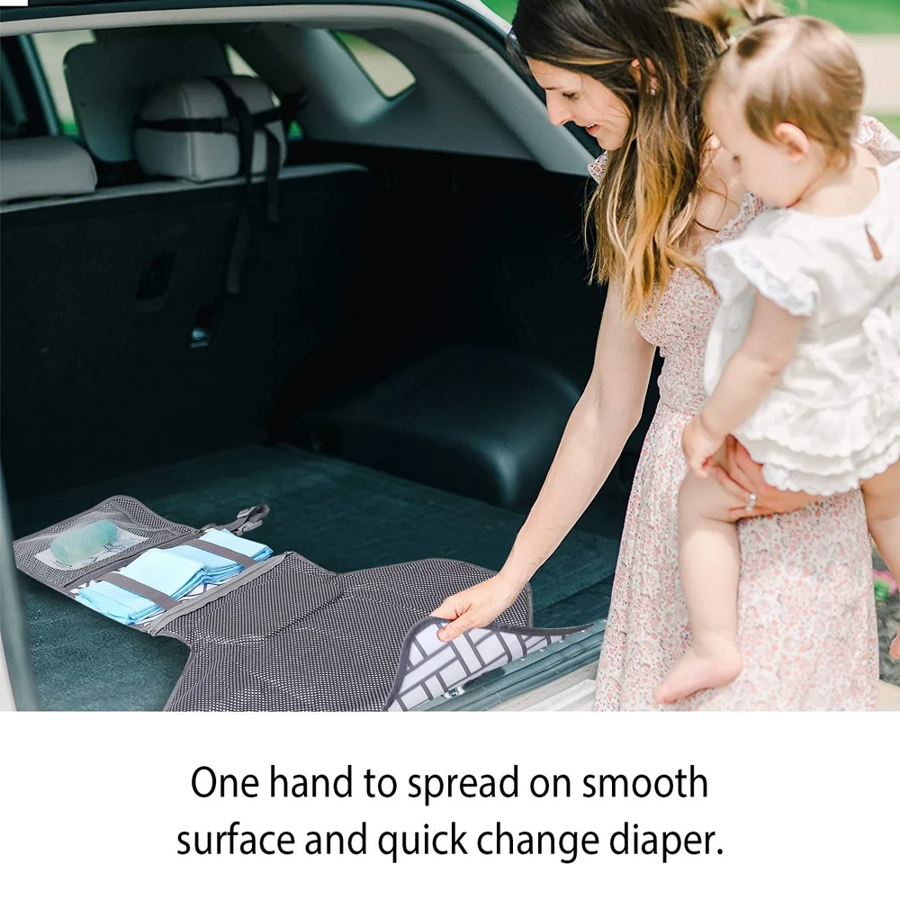 Diaper changing mat being easily spread out in a car's trunk by a parent holding a baby, showcasing convenience and practicality for on-the-go diaper changes.