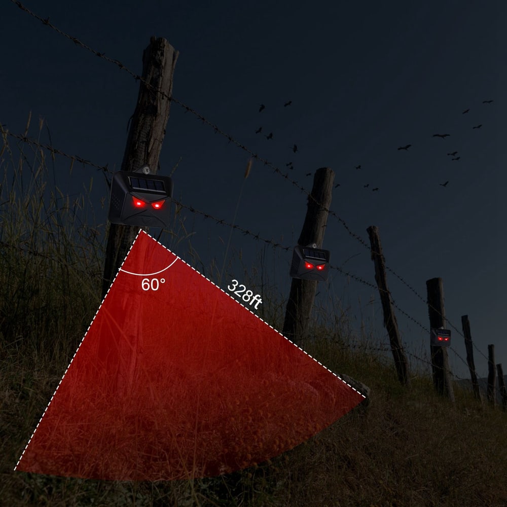 Solar-powered motion sensor alarm with red LED lights, designed for outdoor security, showcasing a 60° detection angle and a range of 328 feet along a barbed-wire fence under a dark sky.