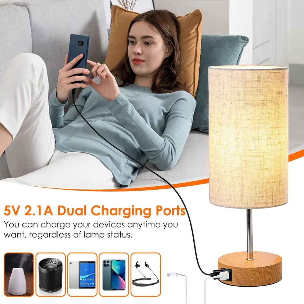 Modern table lamp with dual 5V 2.1A charging ports, designed for convenient device charging while relaxing on a couch, featuring a warm fabric shade and wooden base.