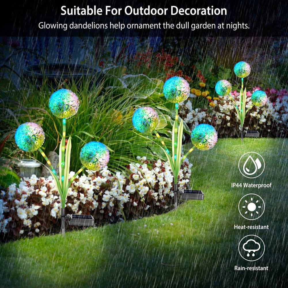 Colorful solar-powered glowing dandelion garden lights with green leaves illuminating a flower bed, designed for outdoor decoration in various weather conditions.