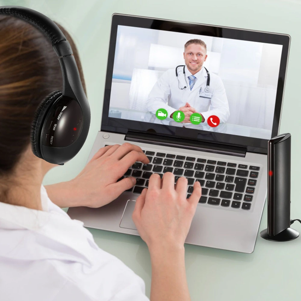 Person using a laptop to participate in a virtual doctor consultation, wearing headphones, with an audio speaker visible on the table, focusing on the healthcare professional displayed on the screen.
