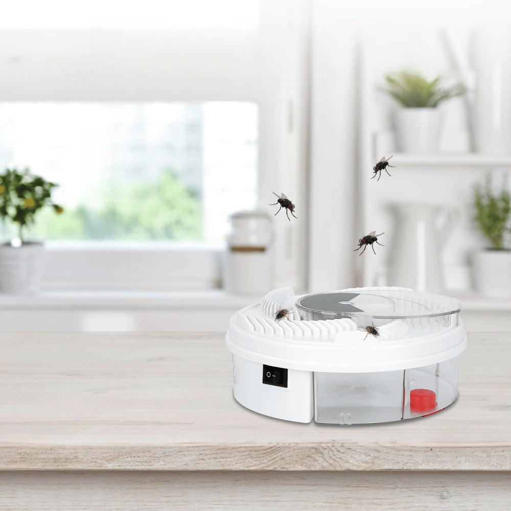 Electric fly trap device on a wooden countertop with flying insects, designed for household pest control in a modern kitchen setting.