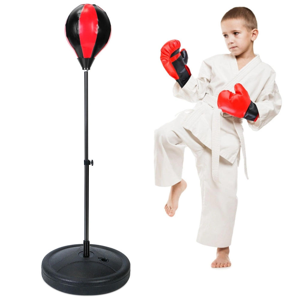 Child practicing martial arts with red boxing gloves beside a freestanding punching bag with a black base and a red and black striking surface.